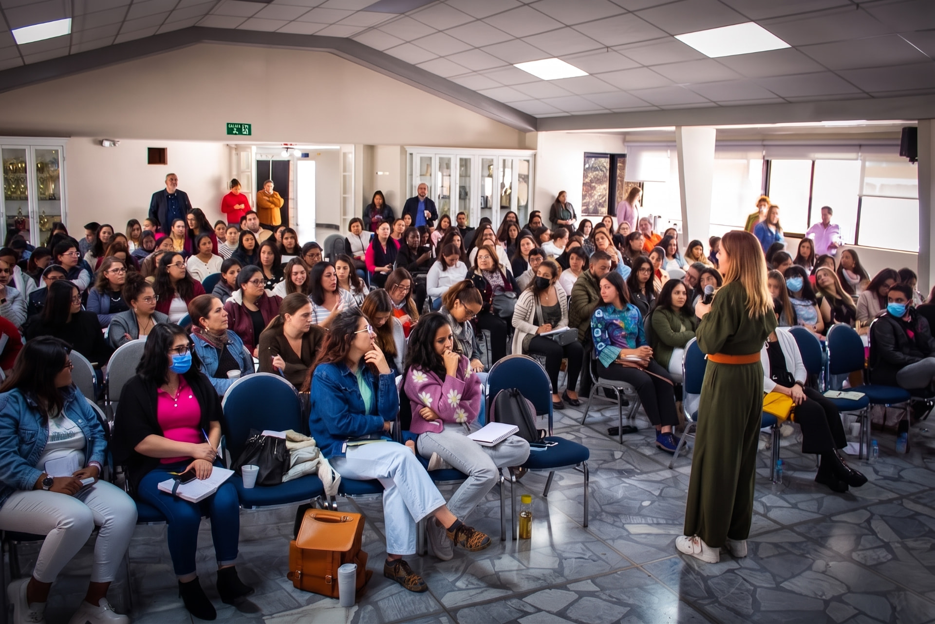 Pilar Londoño dando una charla frente a un auditorio lleno de familias